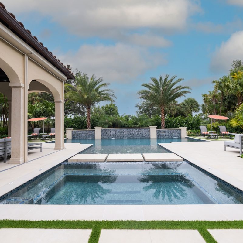 custom in-ground pool and spa with waterfall features and custom glass tile