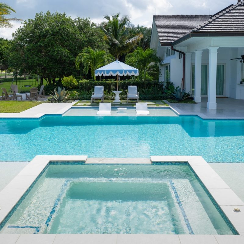 custom pool design with rectilinear modern pool with sun shelves, spa and marble decking